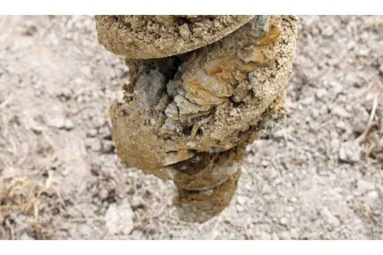 Auger cutting through concrete