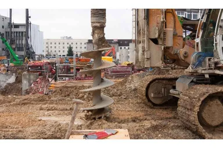 Auger digging into the ground on construction site