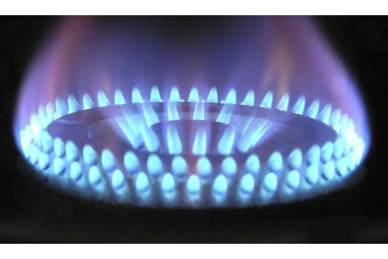 A stove turned on with blue flames 