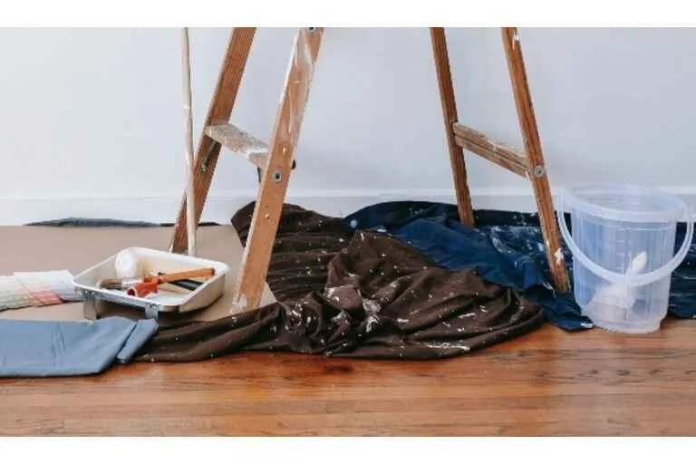 Brown ladder beside painting blankets