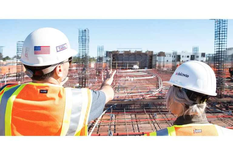Project manager providing instruction to an employee at a construction site