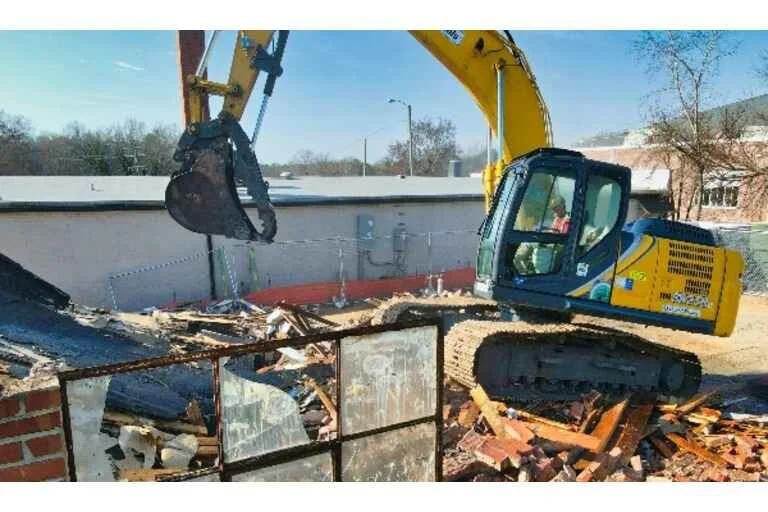 Digger demolishing building