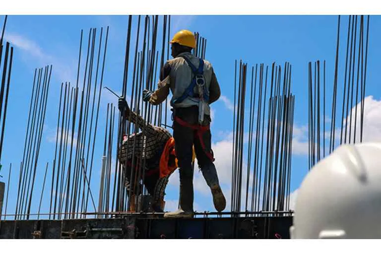 Two men working on exoskeleton