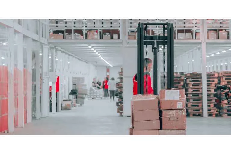 Man using forklift to pick up boxes