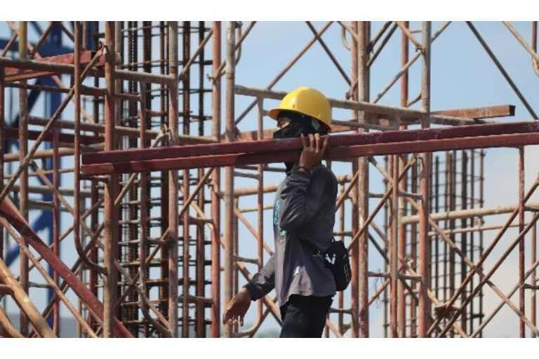 Man carrying scaffolding poles