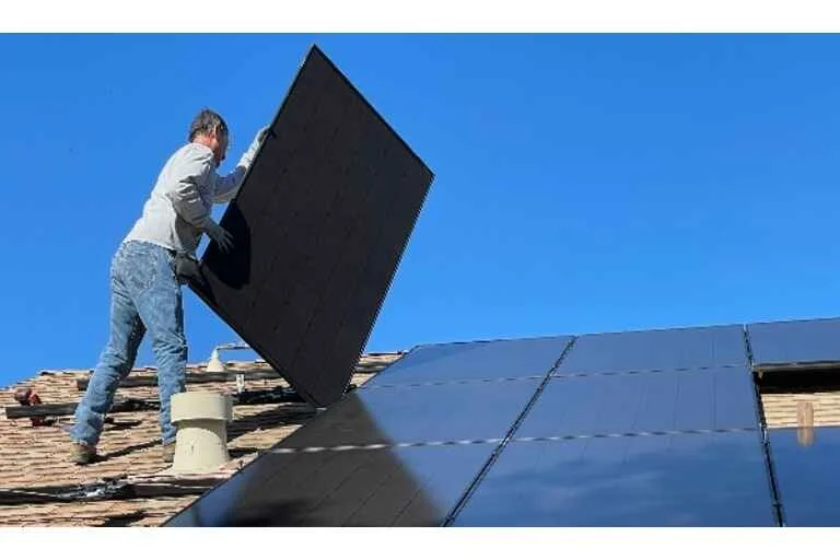 Man fitting solar panels on roof