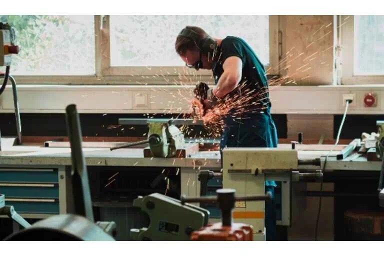 Man using saw creating orange sparks