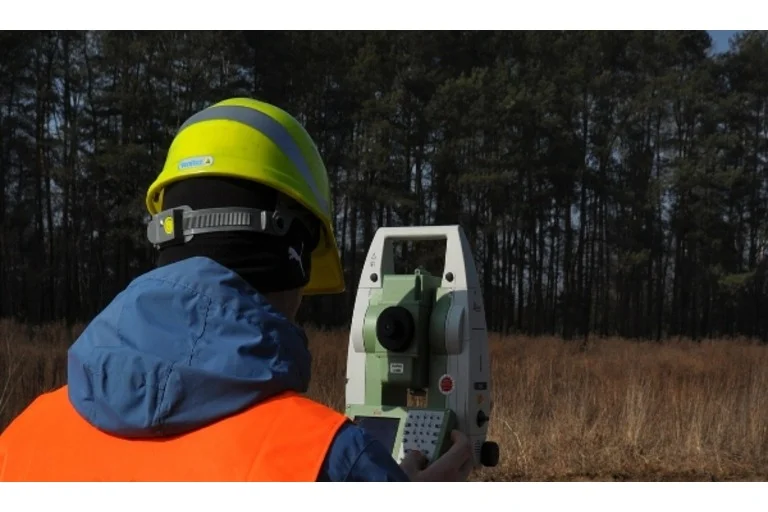 Man wearing hi-vis jacket using laser site level