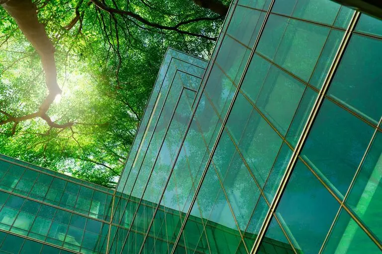 Net zero construction glass building with green trees above