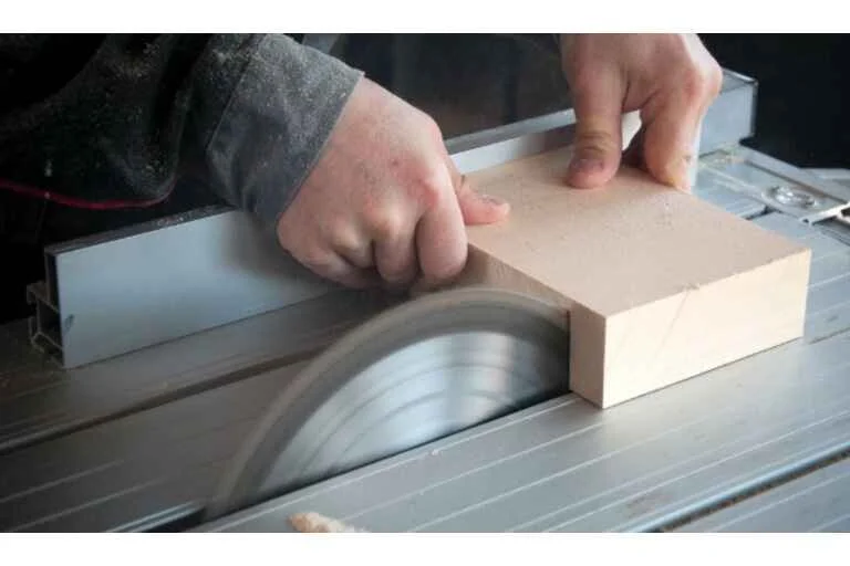 Person cutting block of wood with circular saw