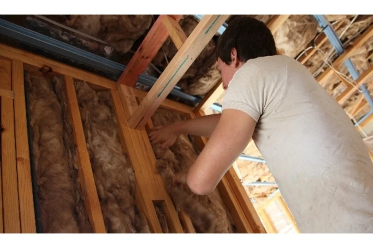 Man padding a wall with insulation