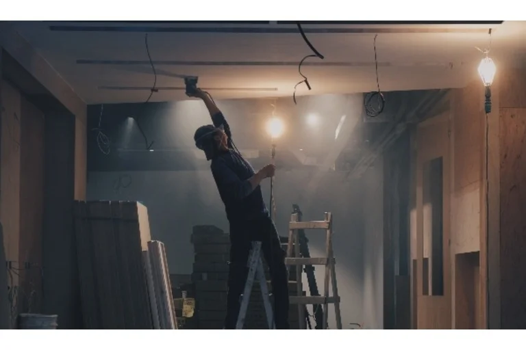 Man using portable light to see when working in construction in a dark room