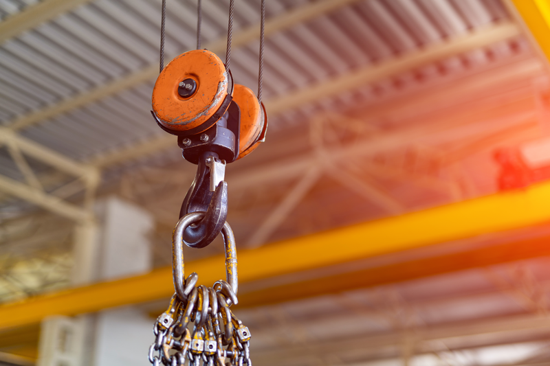 Close up view of industrial metal hook inside factory with corrugated metal roof