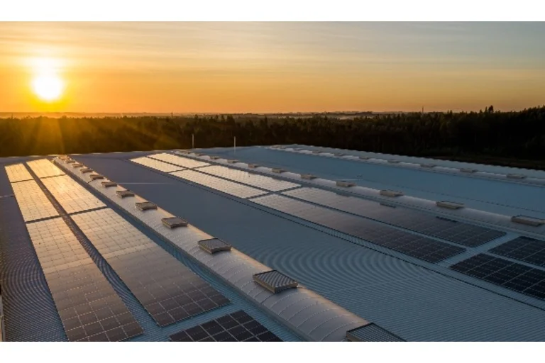 Sun shining onto roof full of solar panels