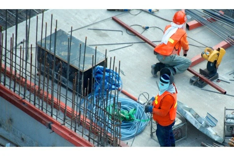 Two men working on a building foundation