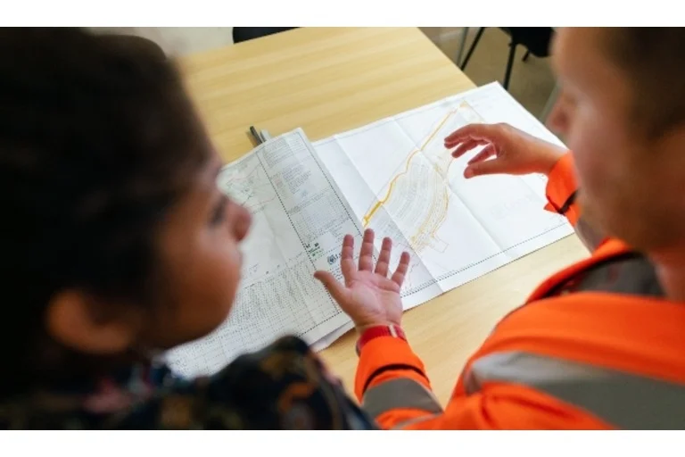 Two people looking over construction plans