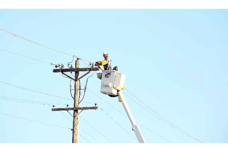 Man in cherry picker working on electricity lines