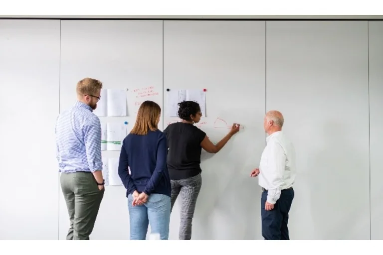 People drawing plans on a whiteboard