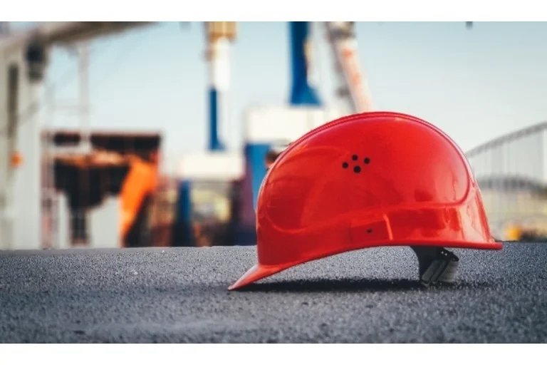 Red hard hat placed on the floor of construction site