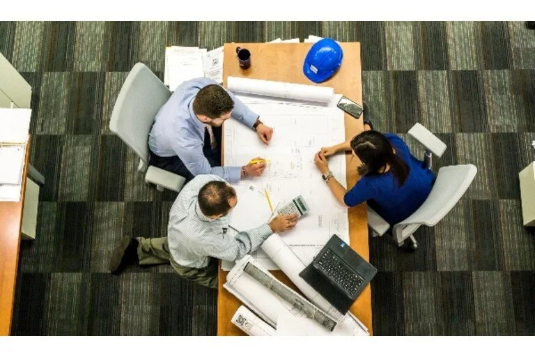 Employees gathered around construction plan